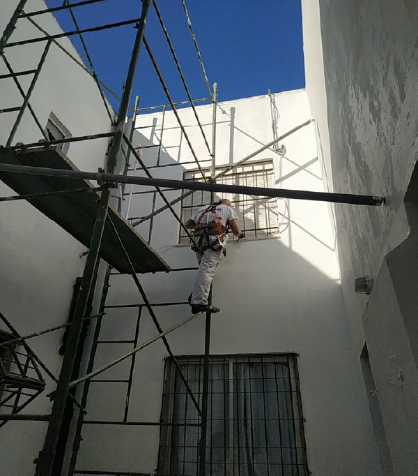 Trabajador en un pozo de aire de edificio.