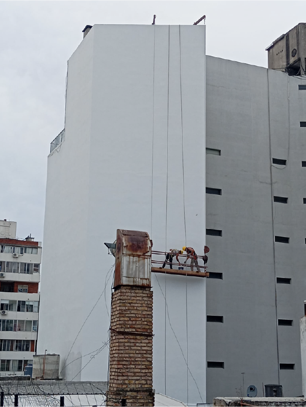 Trabajadores, pintando un edificio en la altura.